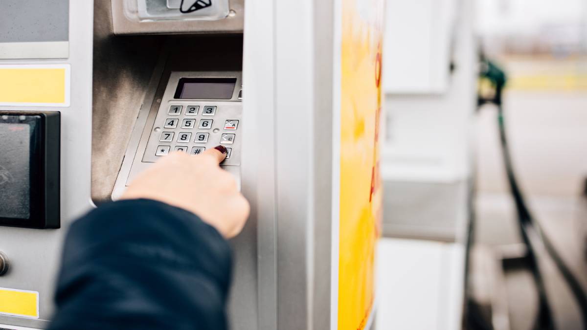 Een klant tikt haar pincode in op de betaalautomaat van een tankstation.