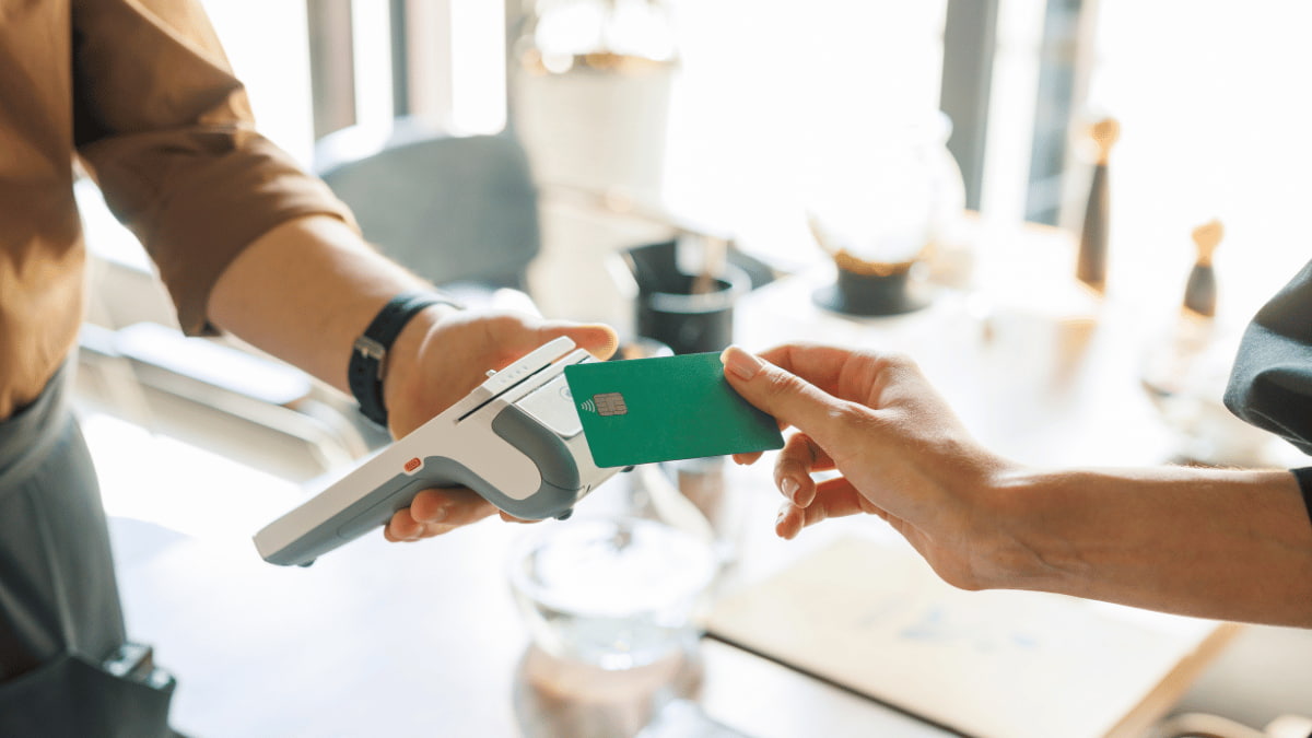 Een klant betaalt contactloos met een bankkaart aan een draagbare betaalterminal.